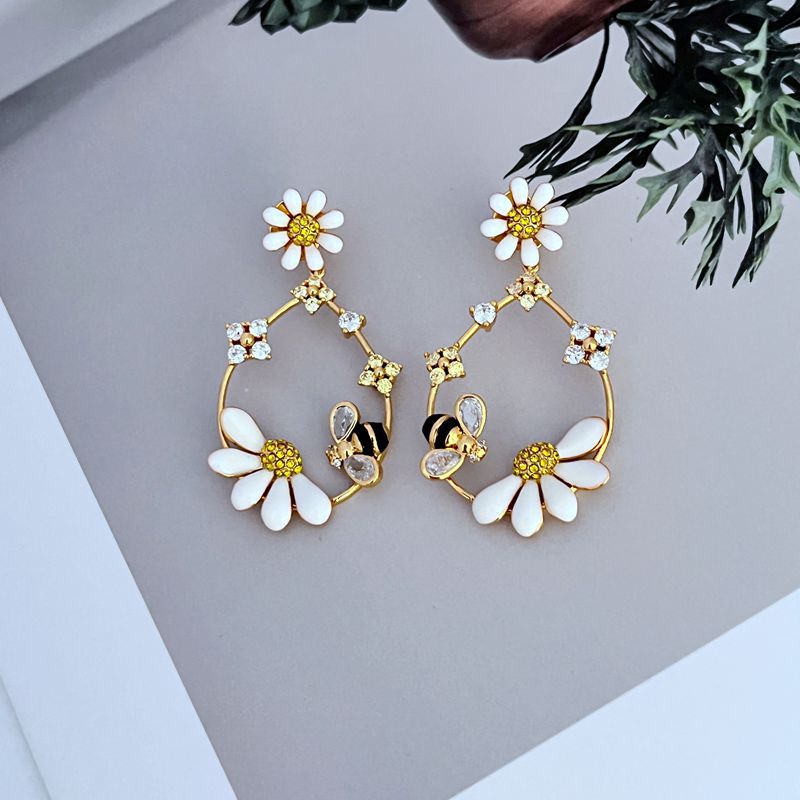  Earrings on a soft blush pink or garden green background, showcasing the pastel enamel flowers along the gold hoop. Alt: “Kate Spade Flower Hoop Earrings – Enamel Floral Hoop Jewelry.”
