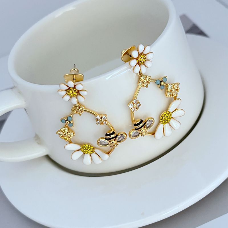  Earrings on a soft blush pink or garden green background, showcasing the pastel enamel flowers along the gold hoop. Alt: “Kate Spade Flower Hoop Earrings – Enamel Floral Hoop Jewelry.”