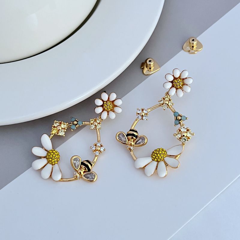  Earrings on a soft blush pink or garden green background, showcasing the pastel enamel flowers along the gold hoop. Alt: “Kate Spade Flower Hoop Earrings – Enamel Floral Hoop Jewelry.”