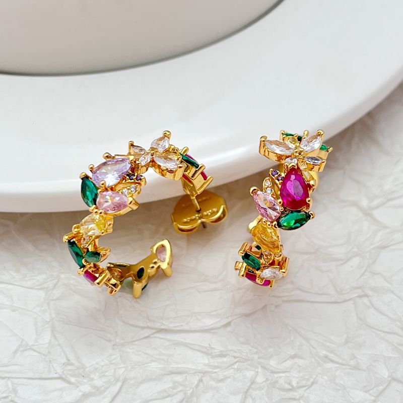 Earrings on a soft moss green or blush pink background, highlighting the floral enamel details along the gold hoop. Alt: “Kate Spade Greenhouse Flora Hoops Earrings – Floral Enamel Hoop Jewelry.”