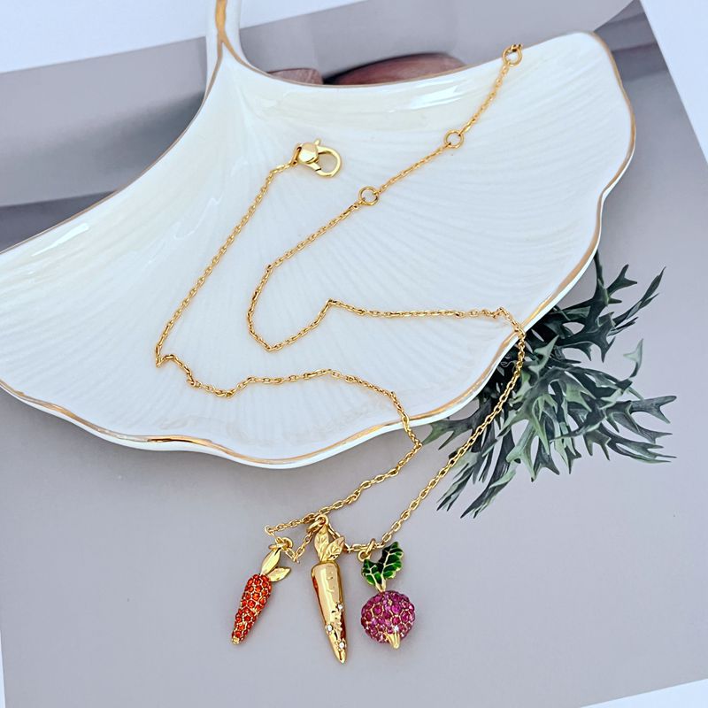 Necklace on a rustic wood or green linen background, highlighting the colorful veggie charm. Alt: “Kate Spade Harvest Time Veggie Charm Pendant Necklace – Playful Garden Jewelry.”