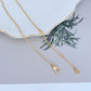 Necklace on a rustic wood or green linen background, highlighting the colorful veggie charm. Alt: “Kate Spade Harvest Time Veggie Charm Pendant Necklace – Playful Garden Jewelry.”