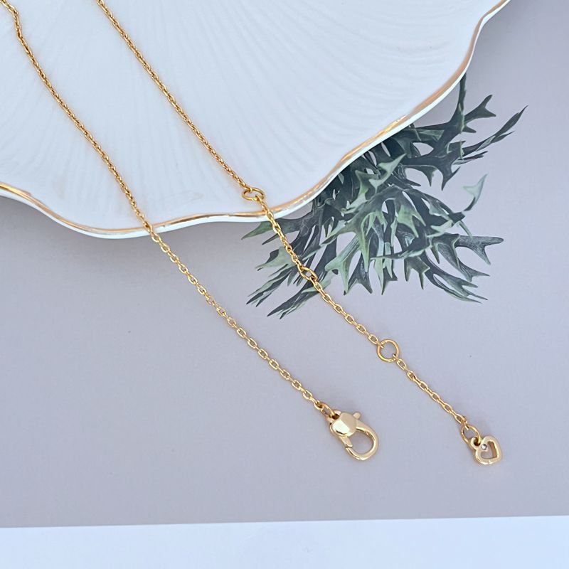Necklace on a rustic wood or green linen background, highlighting the colorful veggie charm. Alt: “Kate Spade Harvest Time Veggie Charm Pendant Necklace – Playful Garden Jewelry.”