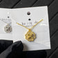 Clean white or soft pastel background — the Kate Spade Heritage Bloom mini pendant displayed on a bust form. The floral enamel pendant catches soft light, showing delicate petal details and the signature Kate Spade aesthetic.