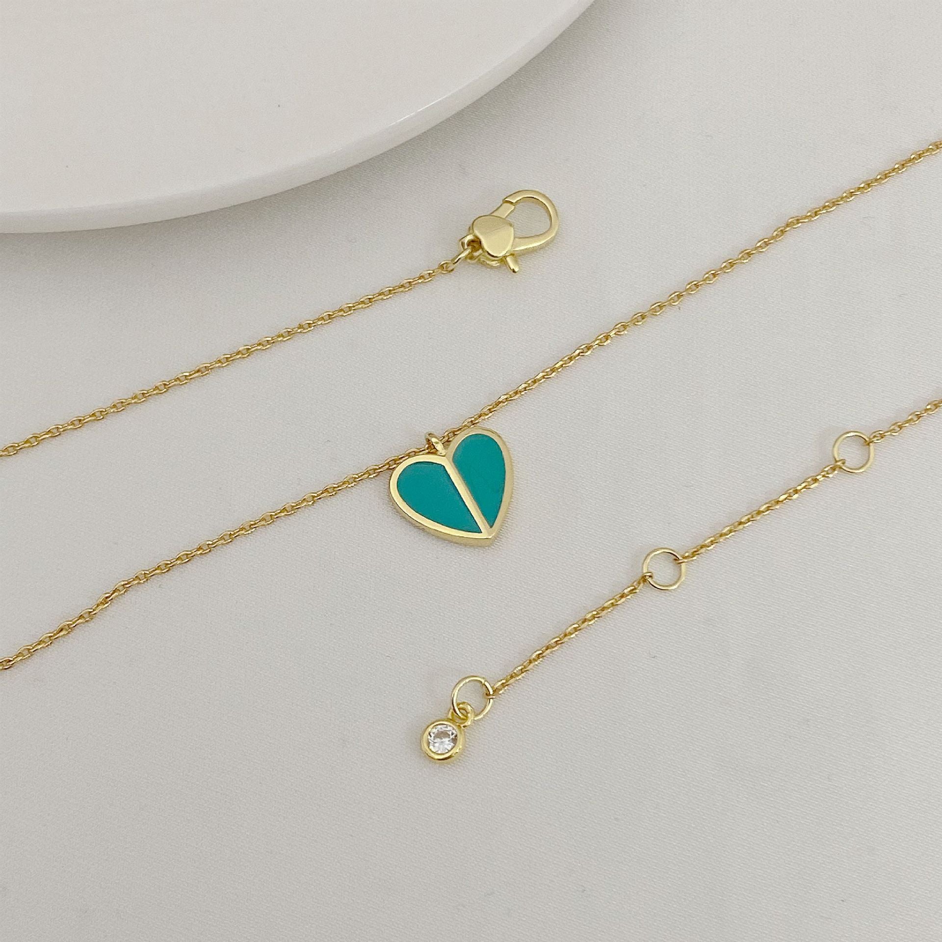 Straight-on to clearly showcase the mini heart pendant with vibrant red enamel and the signature spade detail.