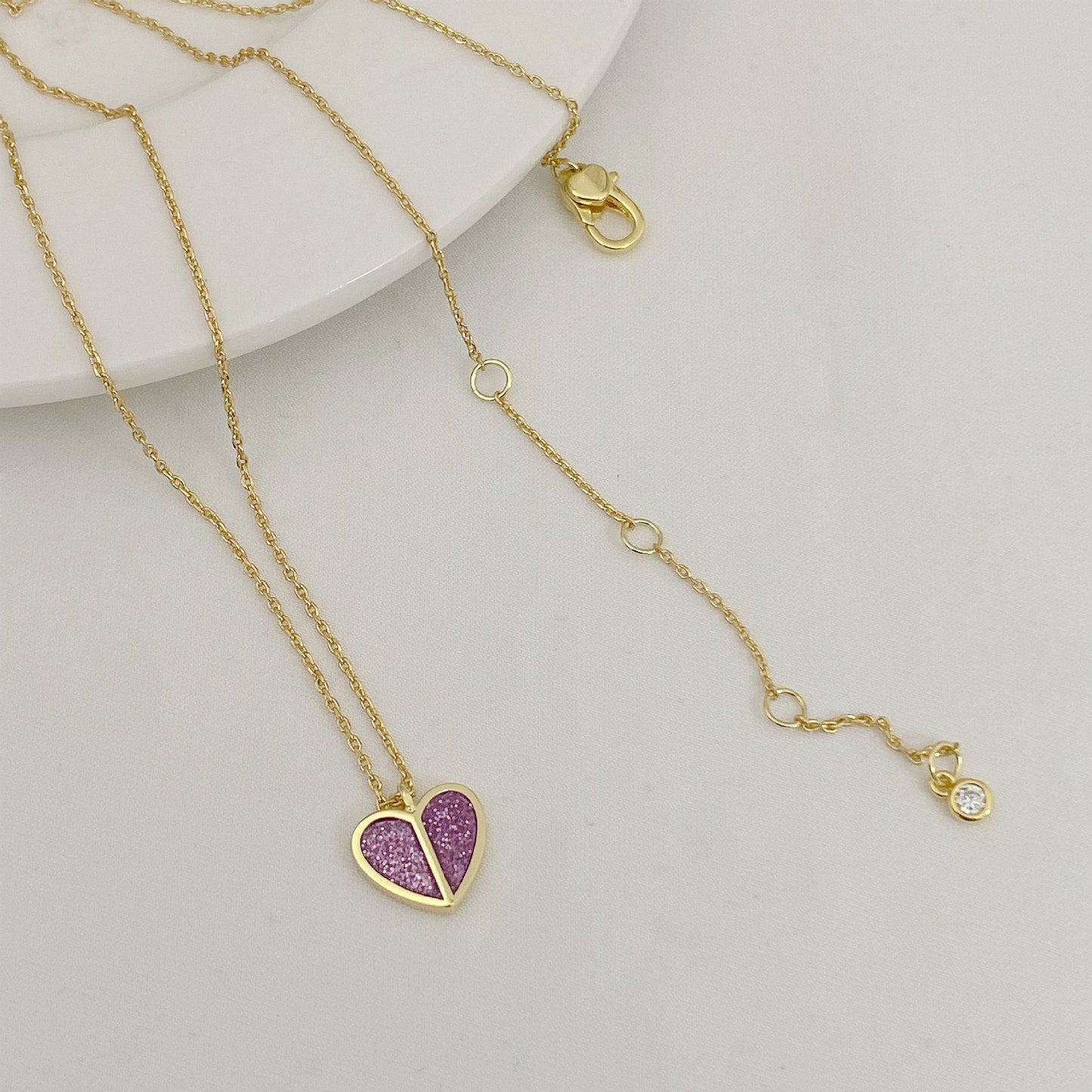 Straight-on to clearly showcase the mini heart pendant with vibrant red enamel and the signature spade detail.