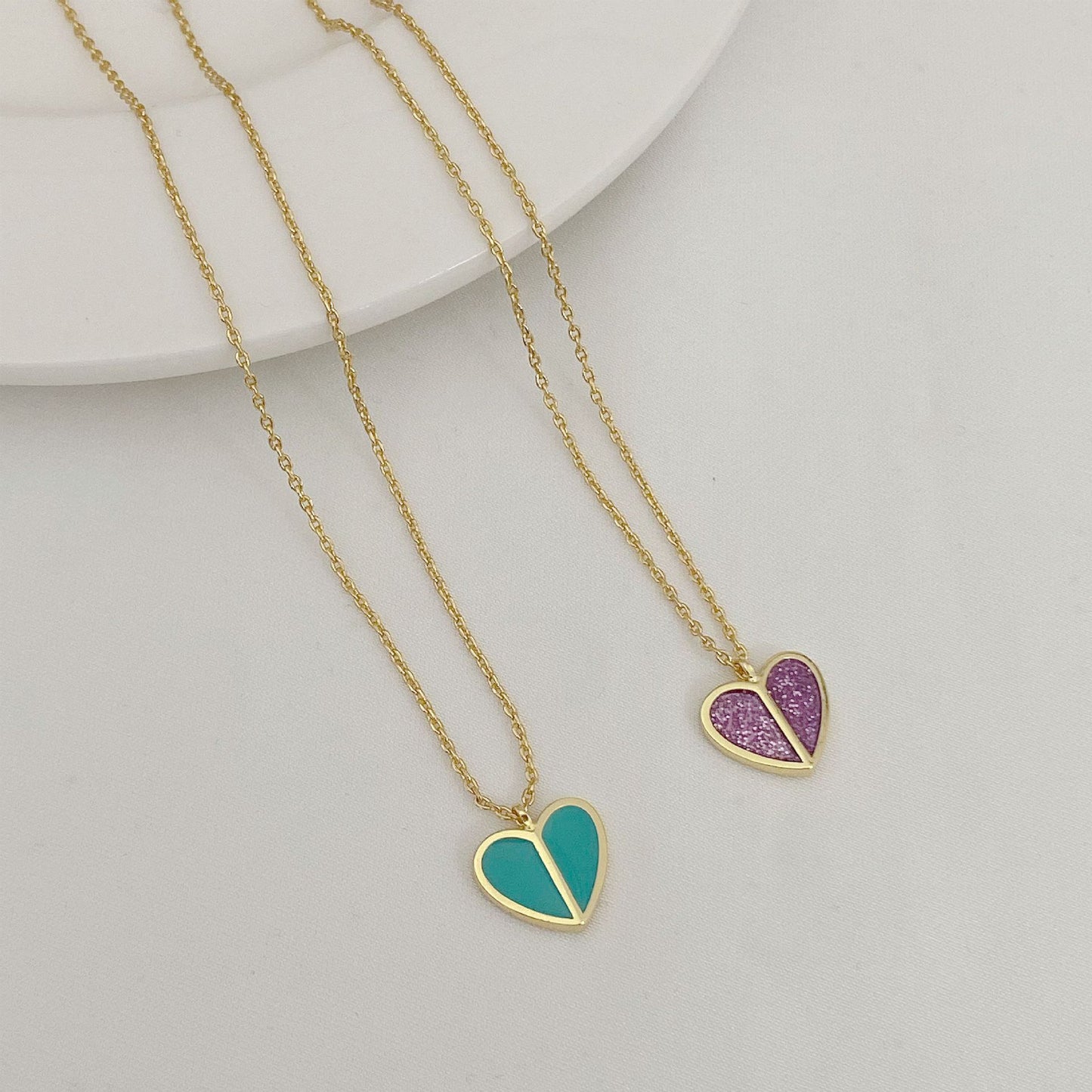 Straight-on to clearly showcase the mini heart pendant with vibrant red enamel and the signature spade detail.