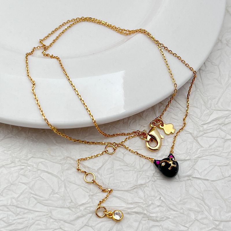 Macro focus on the cat pendant, showing its silhouette, possible textured fur engraving, and secure loop. Alt: “Detailed Mini Cat Charm – Kate Spade Necklace.”