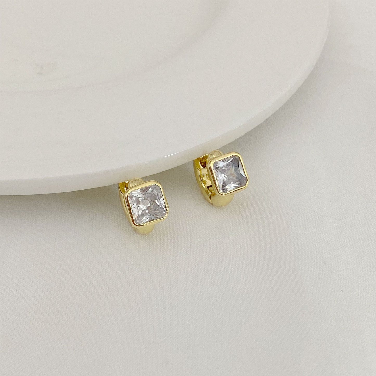 High-definition shot of the pair of earrings laid flat on pure white background, arranged symmetrically.