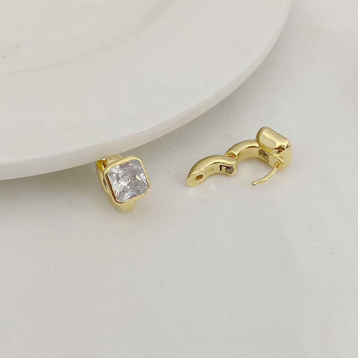 High-definition shot of the pair of earrings laid flat on pure white background, arranged symmetrically.