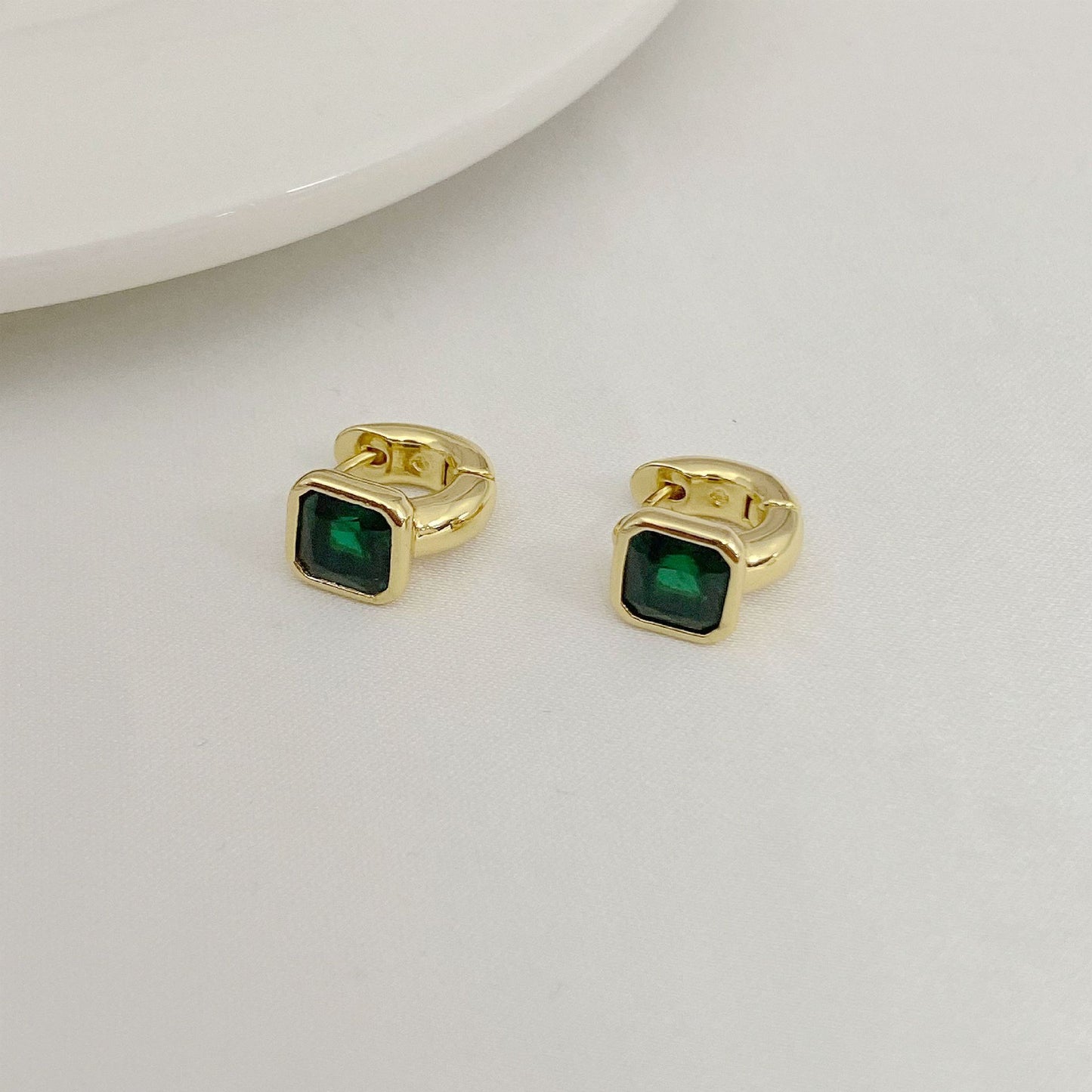 High-definition shot of the pair of earrings laid flat on pure white background, arranged symmetrically.