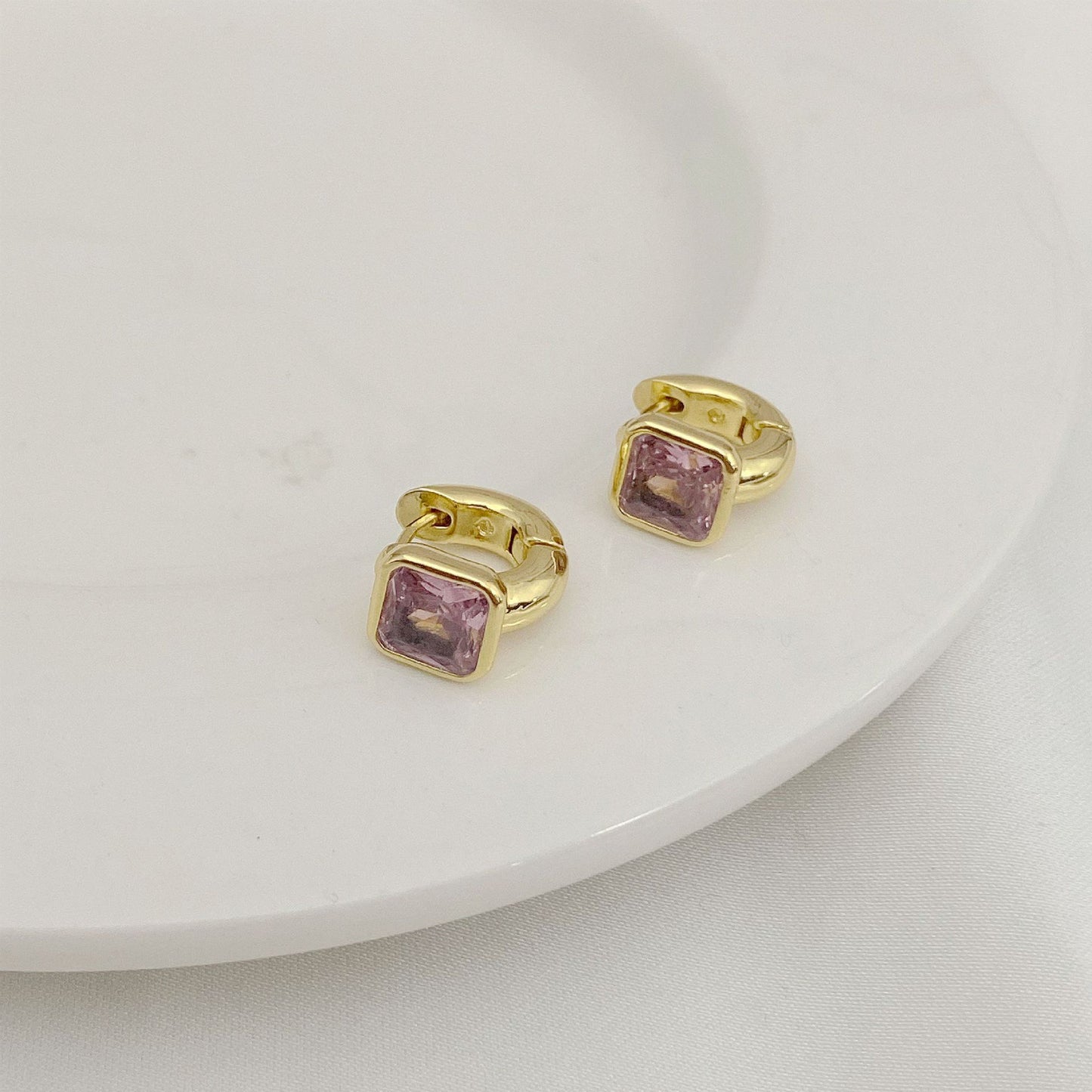 High-definition shot of the pair of earrings laid flat on pure white background, arranged symmetrically.