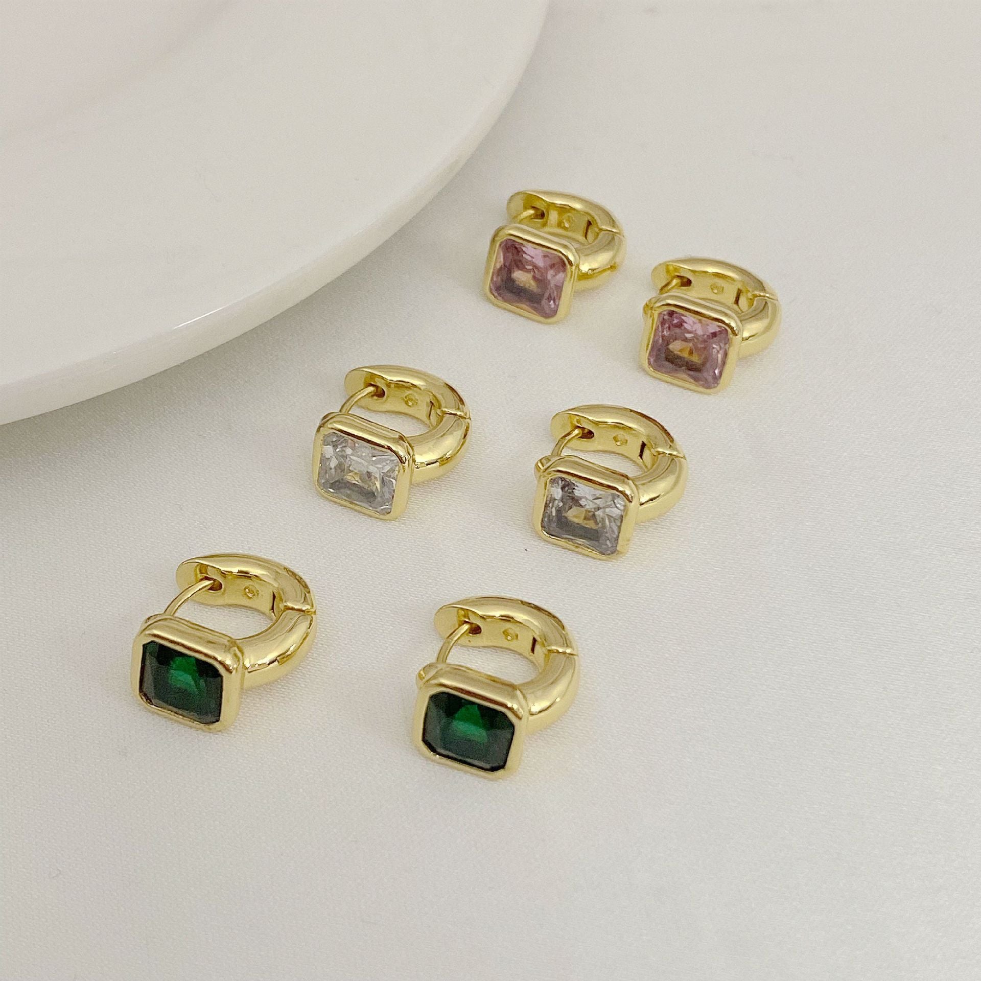 High-definition shot of the pair of earrings laid flat on pure white background, arranged symmetrically.