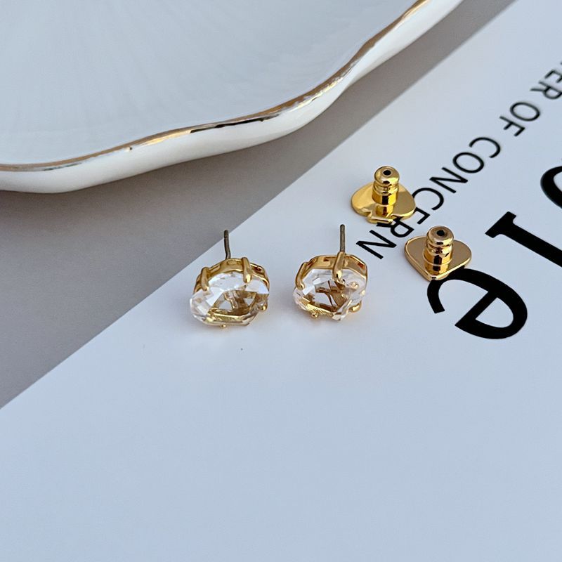 Earrings on a soft white or pale blue background, highlighting the light blue enamel disc with gold "Rise and Shine" lettering. Alt: “Kate Spade Light Blue Rise and Shine Earrings – Blue and Gold Inspirational Jewelry.”