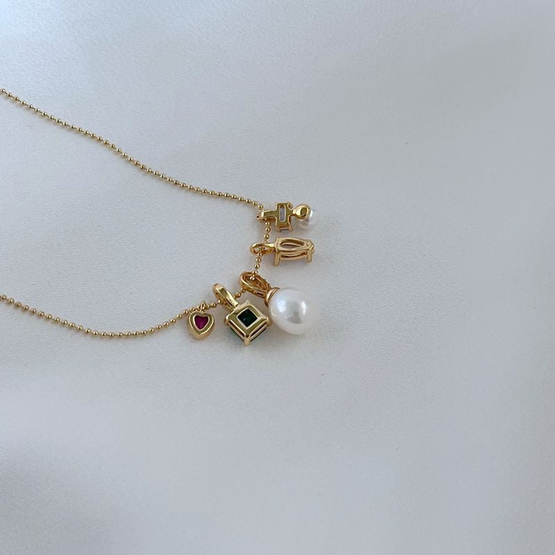 Clean, macro shot of the necklace on a plain background, emphasizing the petite charm and fine chain.