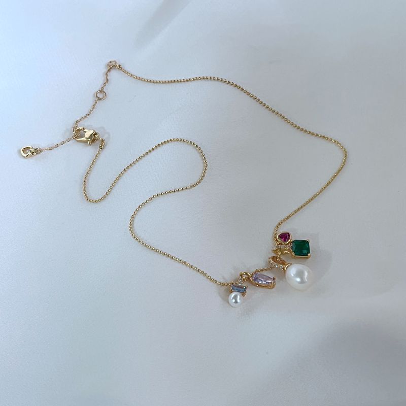 Clean, macro shot of the necklace on a plain background, emphasizing the petite charm and fine chain.