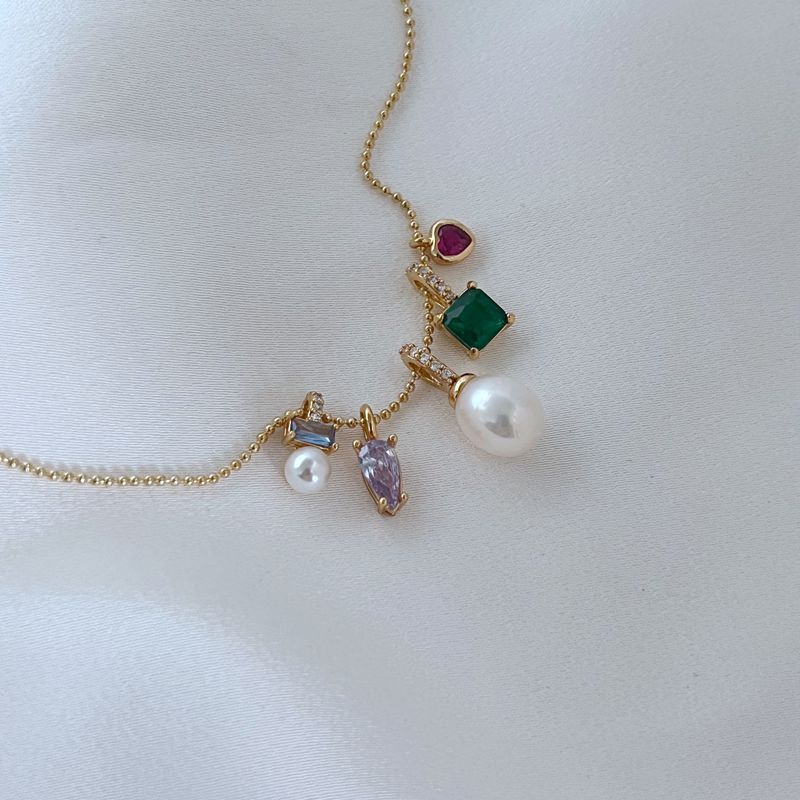 Clean, macro shot of the necklace on a plain background, emphasizing the petite charm and fine chain.