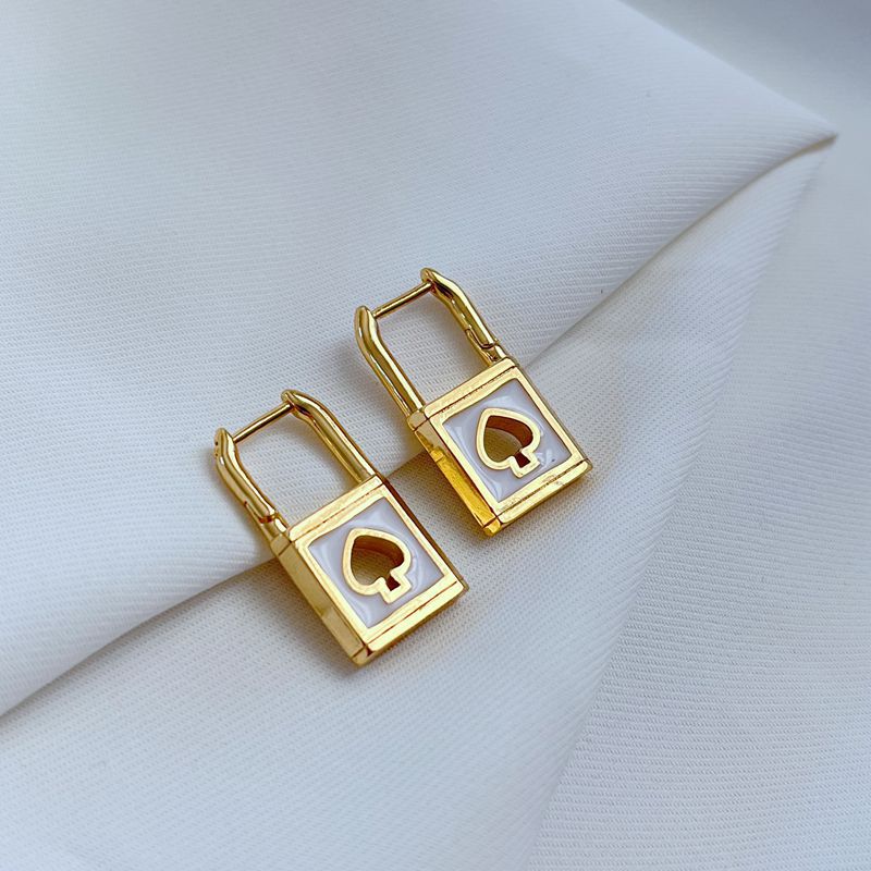 Earrings on a soft black or charcoal background, showcasing the gold spade and padlock charms with black enamel details. Alt: “Kate Spade Lock & Spade Earrings Black & Gold – Signature Enamel Drop Jewelry.”
