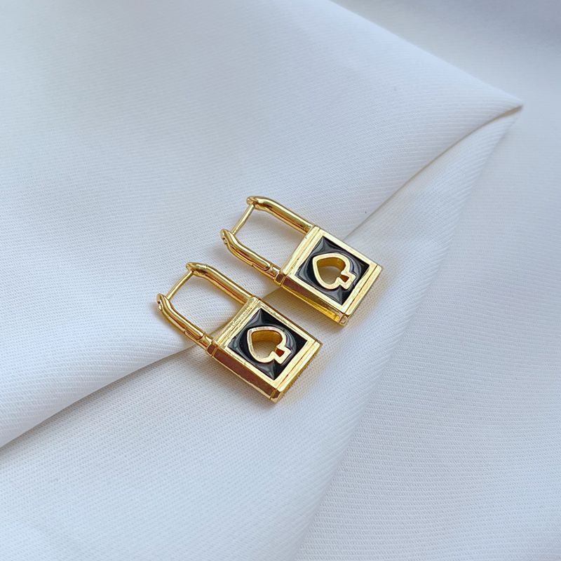 Earrings on a soft black or charcoal background, showcasing the gold spade and padlock charms with black enamel details. Alt: “Kate Spade Lock & Spade Earrings Black & Gold – Signature Enamel Drop Jewelry.”