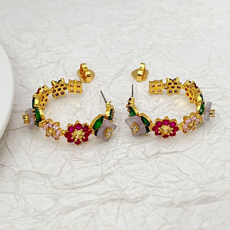 Macro focus on a cluster of enamel flowers and crystal accents along the hoop. Alt: “Multicolor Enamel Flowers & Crystal Detail – Kate Spade Bursting Blooms Hoops.”