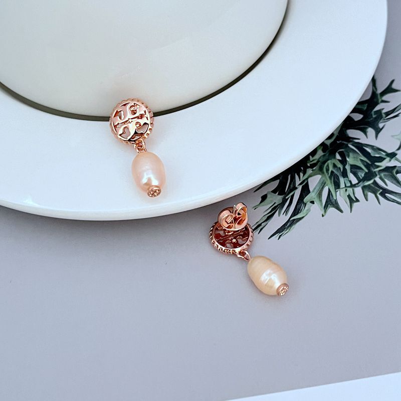 Macro focus on one conch pearl, showing its organic shape, warm pink hue, and natural iridescence. Alt: “Luminous Conch Pearl Detail – Kate Spade Gold Tone Earrings.”