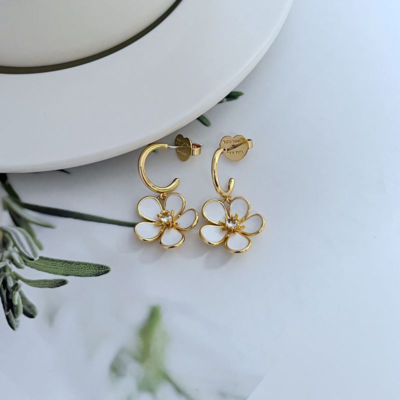  Earrings on a soft cream or blush background, showcasing the ivory enamel pansy within the gold-tone disc. Alt: “Kate Spade New York Gold-Tone Cream Disco Pansy Earrings – Vintage Floral Disc Jewelry.”