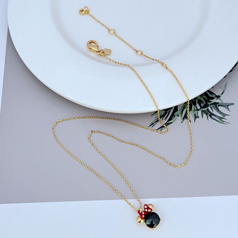 Necklace displayed on a clean, light background (white or pale pink), showing the Minnie slider charm positioned mid-chain. Alt: “Kate Spade New York Minnie Slider Necklace – Disney-Inspired Gold Charm Jewelry.”