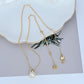 Necklace on a soft, bright background (light blue or creamy white), highlighting the sun pendant's pearl center and crystal halo. Alt: “Kate Spade Sunny Pave & Imitation Pearl Halo Necklace – Radiant Sun Motif Jewelry.”