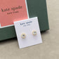 Gold and crystal stud earrings on a Kate Spade card with a green box in the background.