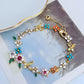 Bracelet displayed on a soft linen or weathered wood background, evoking a rustic, pastoral feel. Alt: “Kate Spade Pastoral Style Floral Bracelet – Enamel Flower Charm Jewelry.”