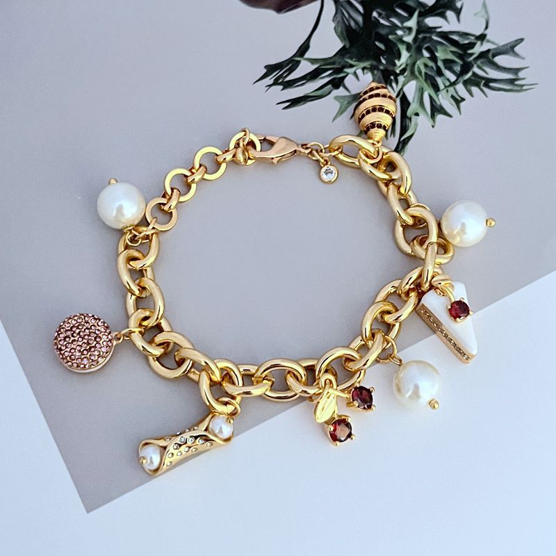 Bracelet displayed on a light marble or pastel backdrop, charms clearly visible. Alt: “Kate Spade Pastry Shop Charm Bracelet – Sweet Bakery-Themed Jewelry.”