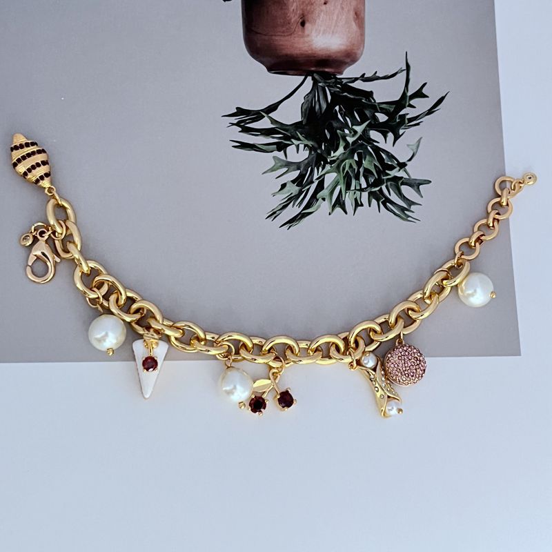  Bracelet displayed on a light marble or pastel backdrop, charms clearly visible. Alt: “Kate Spade Pastry Shop Charm Bracelet – Sweet Bakery-Themed Jewelry.”