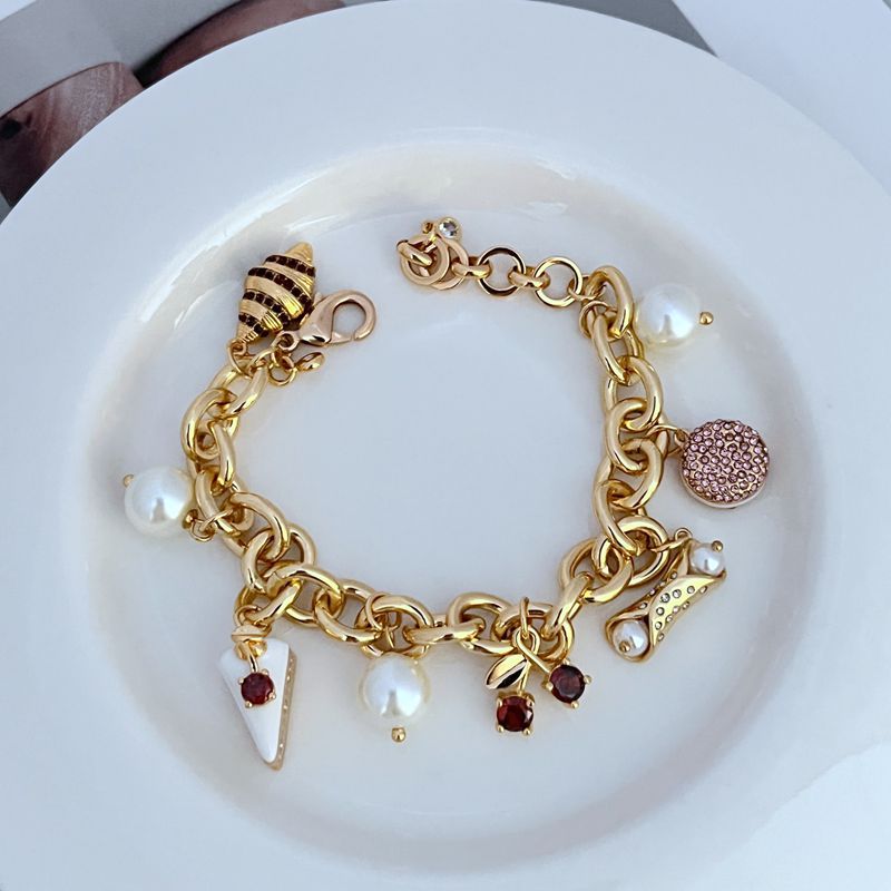  Bracelet displayed on a light marble or pastel backdrop, charms clearly visible. Alt: “Kate Spade Pastry Shop Charm Bracelet – Sweet Bakery-Themed Jewelry.”