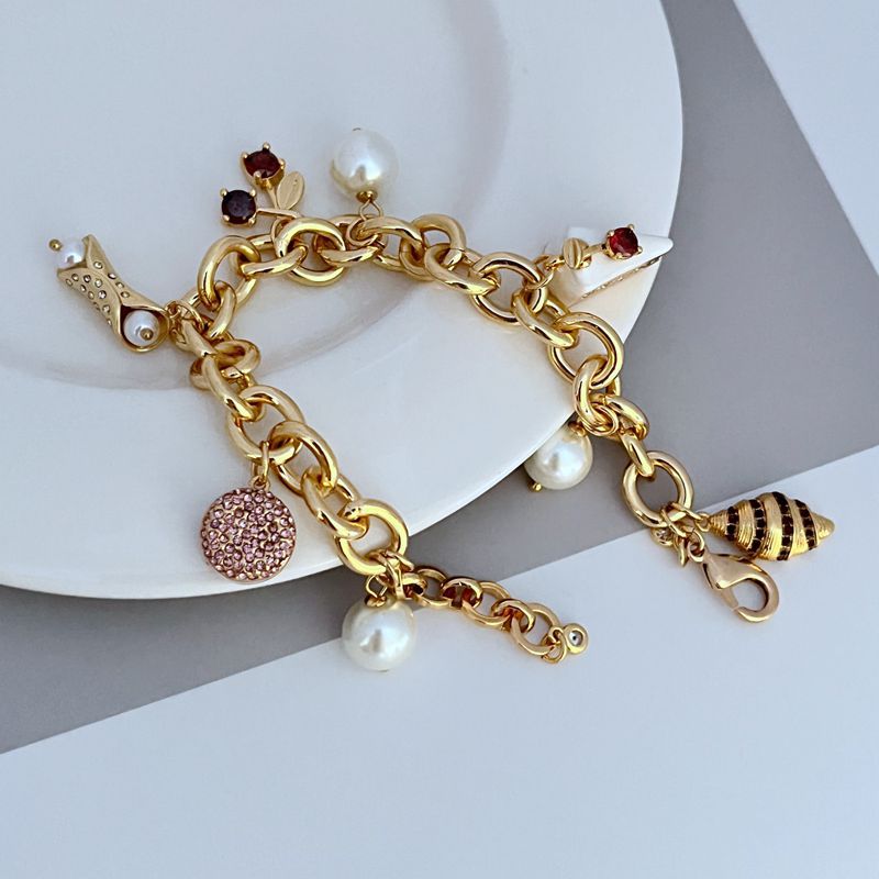  Bracelet displayed on a light marble or pastel backdrop, charms clearly visible. Alt: “Kate Spade Pastry Shop Charm Bracelet – Sweet Bakery-Themed Jewelry.”