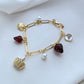  Bracelet displayed on a red gingham or soft cream background, evoking a classic picnic aesthetic. Alt: “Kate Spade Picnic Basket and Strawberry Bracelet – Summer Enamel Charm Jewelry.”