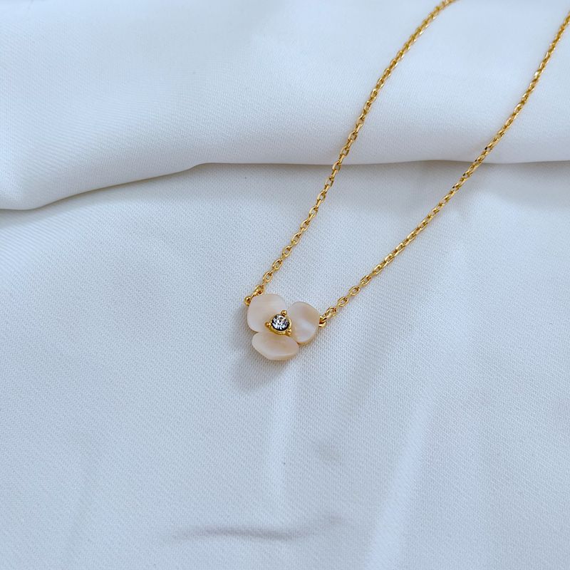 Clean, macro shot of the necklace on a plain background, focusing on the miniature pansy pendant and fine chain.