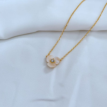 Clean, macro shot of the necklace on a plain background, focusing on the miniature pansy pendant and fine chain.