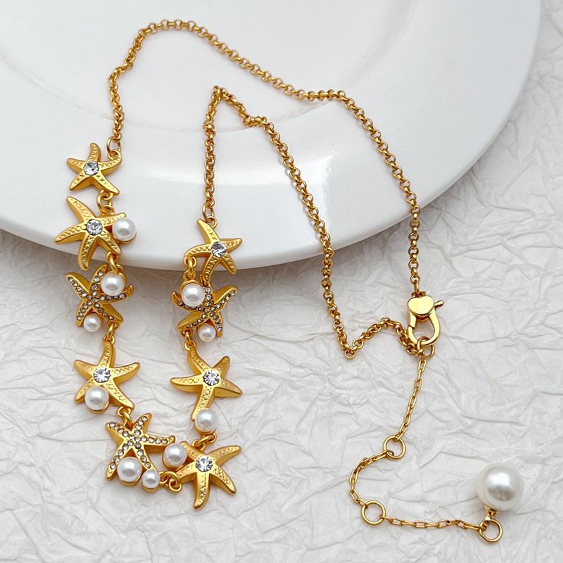 Necklace laid flat on a sandy-beige or light blue background, emphasizing the starfish pendant's shape and detail. Alt: “Kate Spade Sea Star Necklace – Delicate Starfish Pendant Jewelry.”