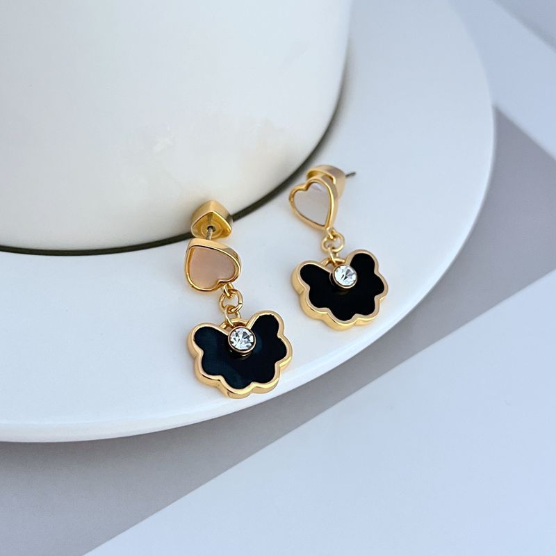 Earrings on a soft blush pink or cream background, showcasing the spade-shaped floral pendant with enamel detailing. Alt: “Kate Spade Spade Flower Drop Earrings – Signature Floral Enamel Jewelry.”