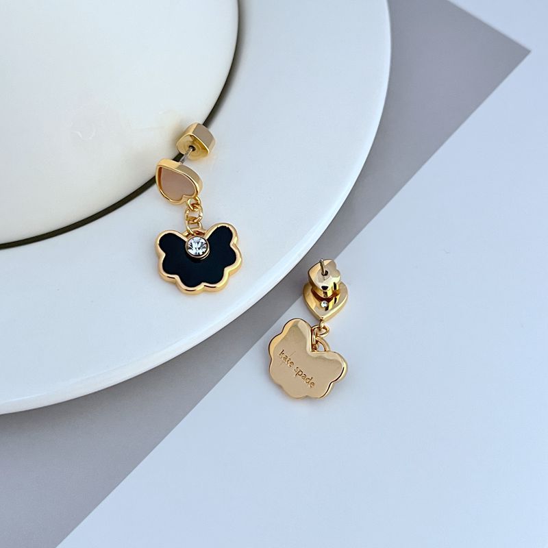 Earrings on a soft blush pink or cream background, showcasing the spade-shaped floral pendant with enamel detailing. Alt: “Kate Spade Spade Flower Drop Earrings – Signature Floral Enamel Jewelry.”