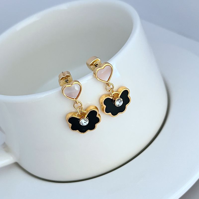 Earrings on a soft blush pink or cream background, showcasing the spade-shaped floral pendant with enamel detailing. Alt: “Kate Spade Spade Flower Drop Earrings – Signature Floral Enamel Jewelry.”