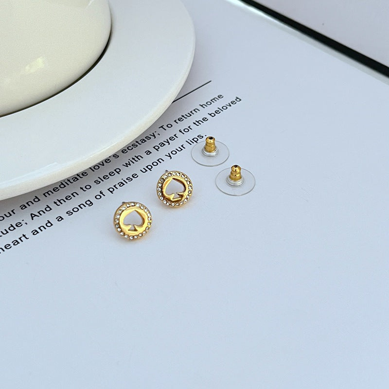  Earrings on a clean white or soft grey background, showcasing the crystal-pavé spade shape. Alt: “Kate Spade Spot The Spade Gold Tone Crystal Stud Earrings – Pavé Spade Jewelry.”