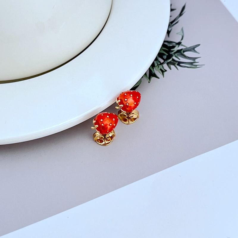 Earrings on a soft cream or blush pink background, highlighting the glossy red strawberry and gold finish. Alt: “Kate Spade Strawberry Fields Stud Gold Earrings – Enamel Fruit Jewelry New.”