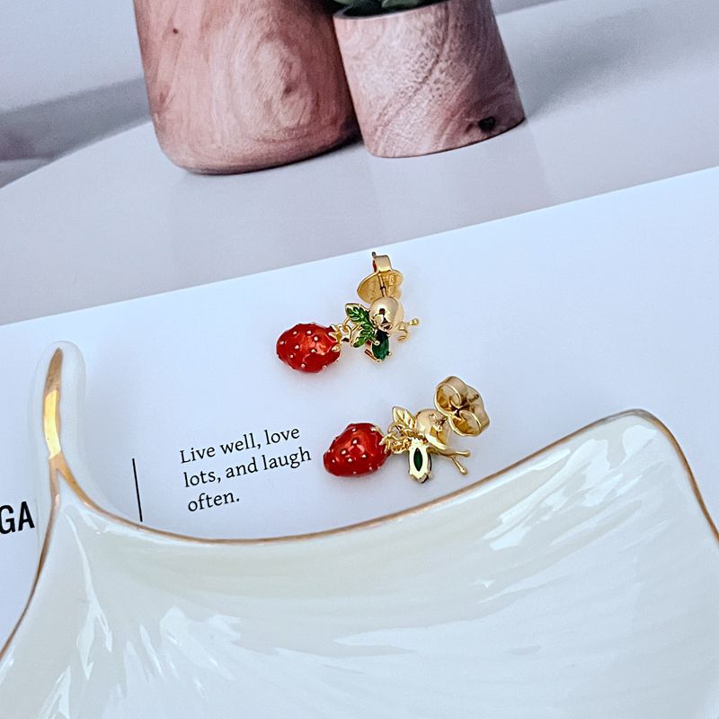  Earrings on soft pink or garden green background. Alt: “Kate Spade Strawberry Fleur Drop Earrings – Enamel Fruit Floral Jewelry.”