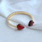 Bracelet on a light, natural background (white wood or pale pink), highlighting the strawberry enamel details. Alt: “Kate Spade Strawberry Gold Bracelet – Dainty Fruit Charm Jewelry.”