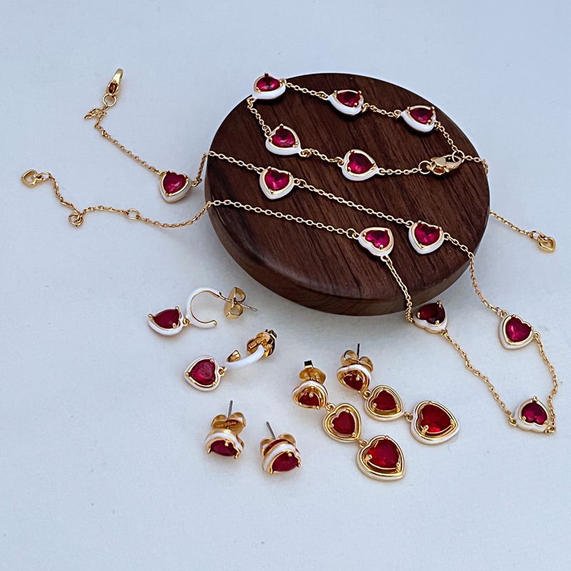 Clean shot of the bracelet laid flat or slightly curved, on a neutral background, clearly showing the line of heart charms.

