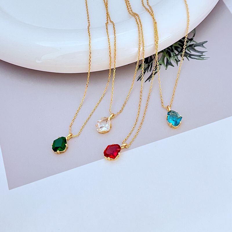 Necklace displayed on a dark background (navy or charcoal) to make the gold and fuchsia gemstone pop. Alt: “Kate Spade Treasure Trove Gold Necklace with Fuchsia Gem – Bold Statement Pendant.”