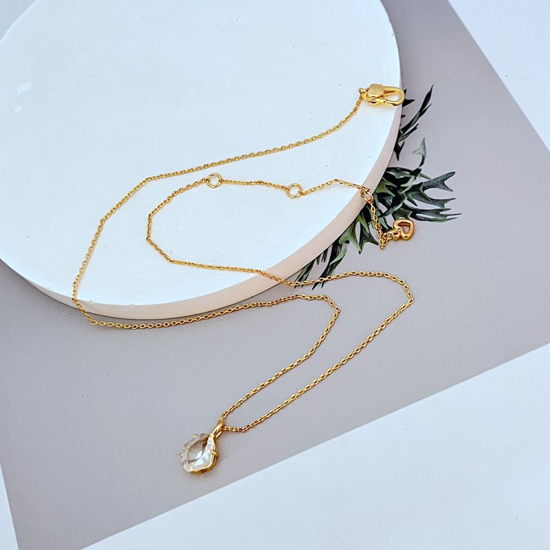 Necklace displayed on a dark background (navy or charcoal) to make the gold and fuchsia gemstone pop. Alt: “Kate Spade Treasure Trove Gold Necklace with Fuchsia Gem – Bold Statement Pendant.”