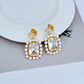 Earrings on soft blush or cream background. Alt: “Kate Spade Victoria Drop Earrings – Crystal & Pearl Dangle Jewelry.”