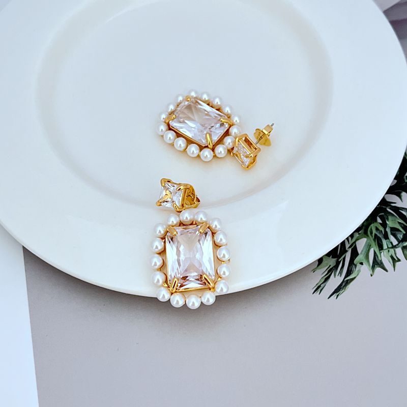 Earrings on soft blush or cream background. Alt: “Kate Spade Victoria Drop Earrings – Crystal & Pearl Dangle Jewelry.”